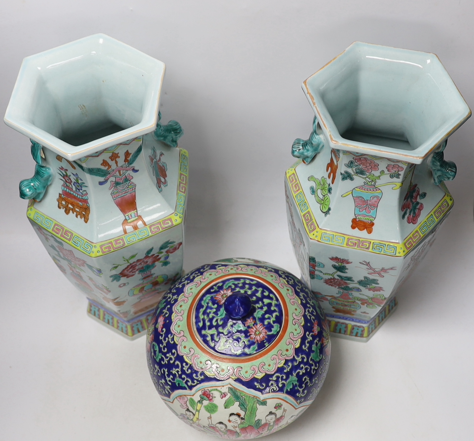 A pair of Chinese famille rose vases and a similar jar and cover, 38cm